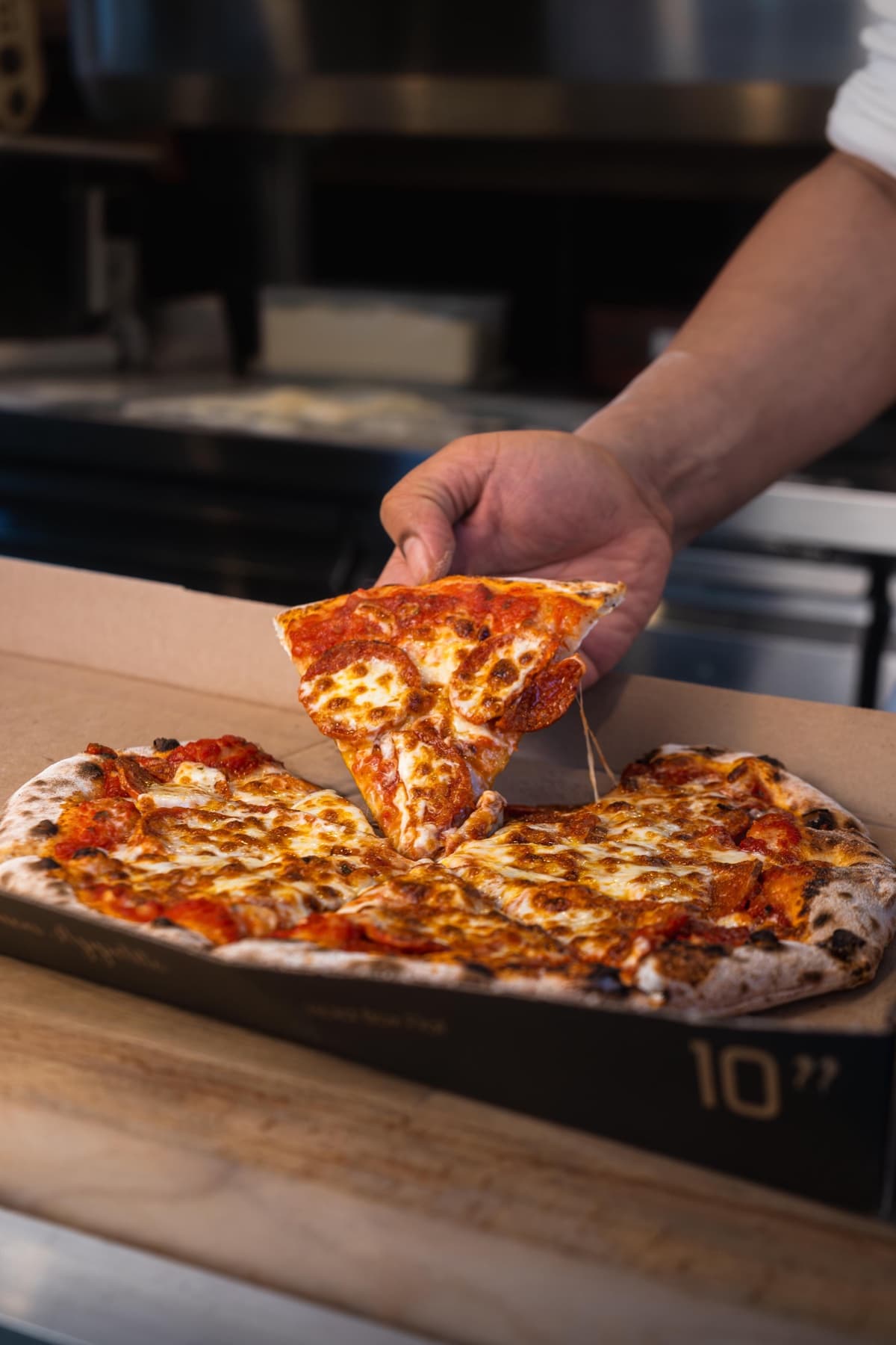 A freshly baked Pizza Press pizza being served from its box