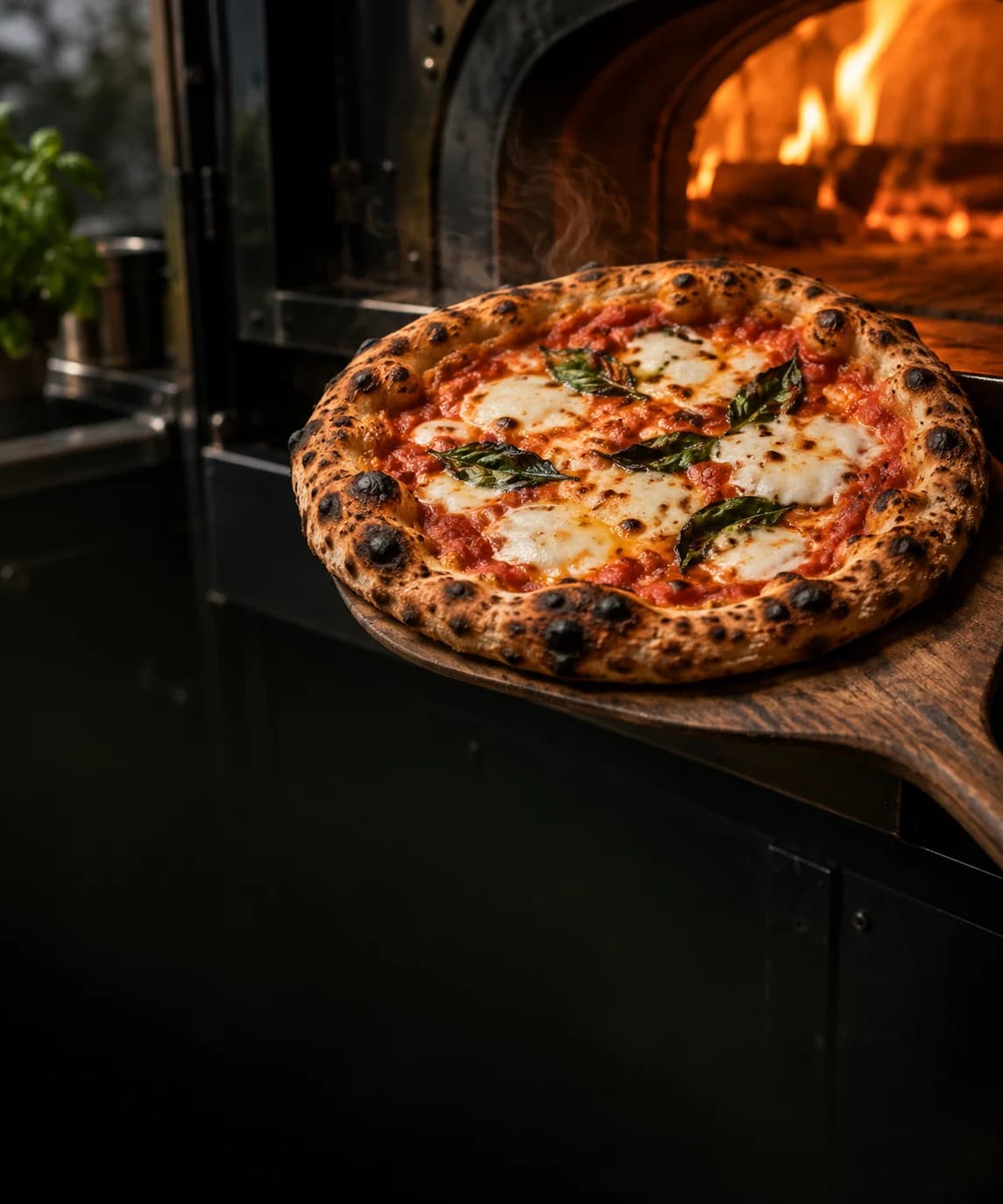 A freshly stone-baked Pizza Press pizza beside the flame of the van's oven